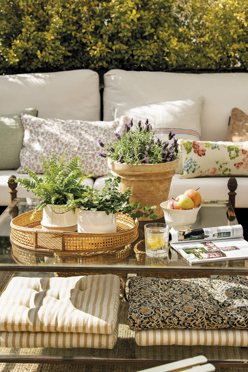 Terraza con zona de estar con mesa de hierro y plantas aromáticas